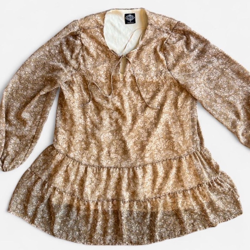 Gold/tan floral blouse with tie neck and ruffle hem. Size: Small like new!